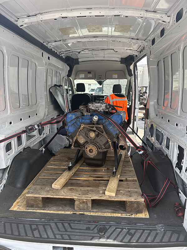 An engine block, secured inside a small freight van